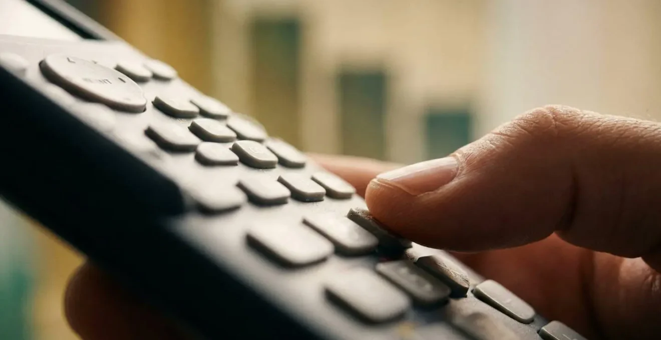 Main tenant une calculatrice avec graphiques de baisse sur écran flou en arrière-plan