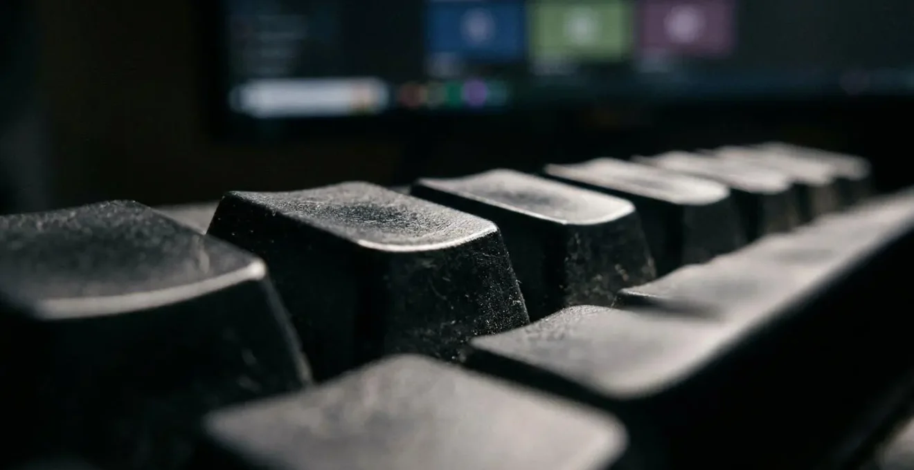 Vue macro d'un clavier d'ordinateur avec reflet d'écran montrant des comparaisons floues