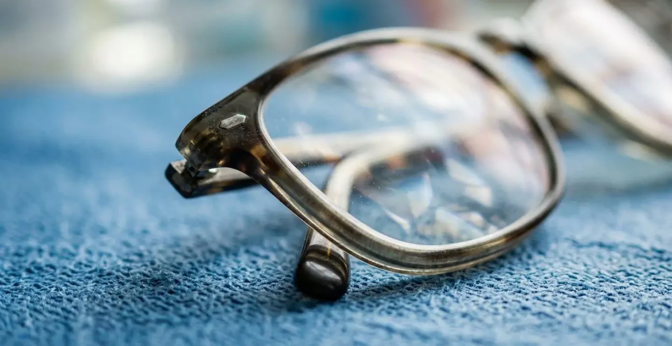 Composition macro de lunettes posées sur surface texturée avec reflets abstraits
